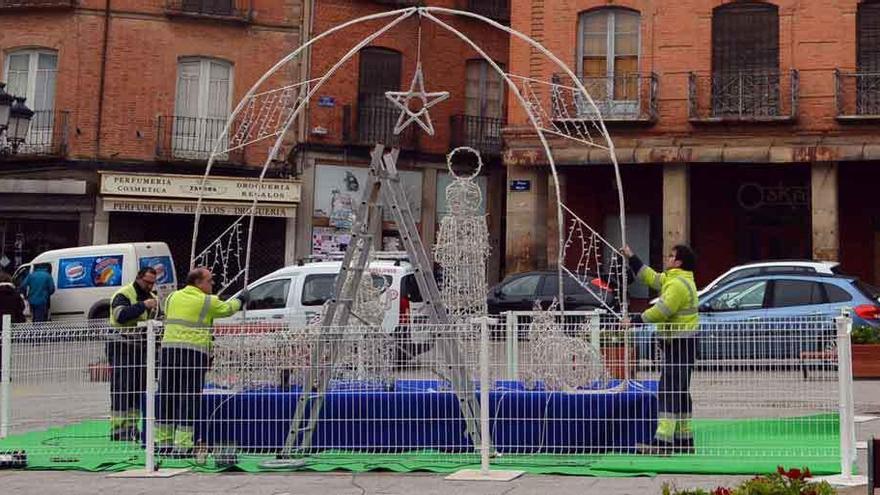 Operarios municipales instalaban ayer el belén de la Plaza Mayor y las luminarias.