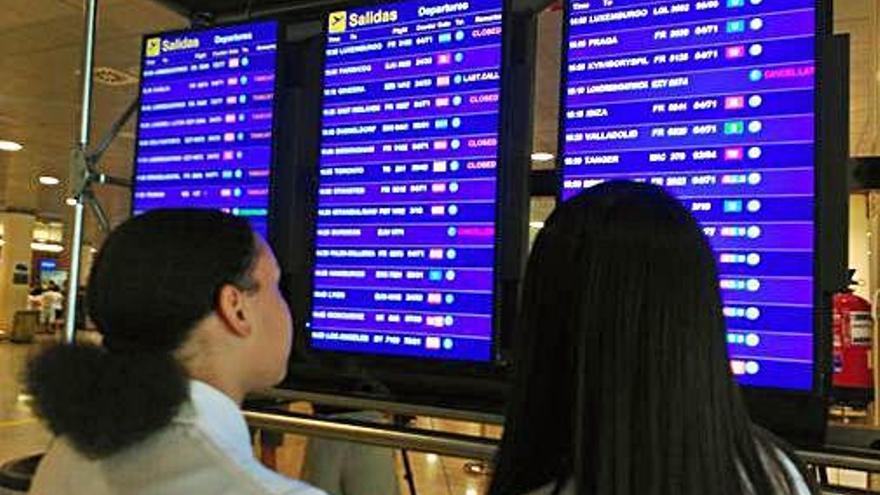 Dues dones miren l&#039;estat del seu vol a l&#039;aeroport de Barcelona.