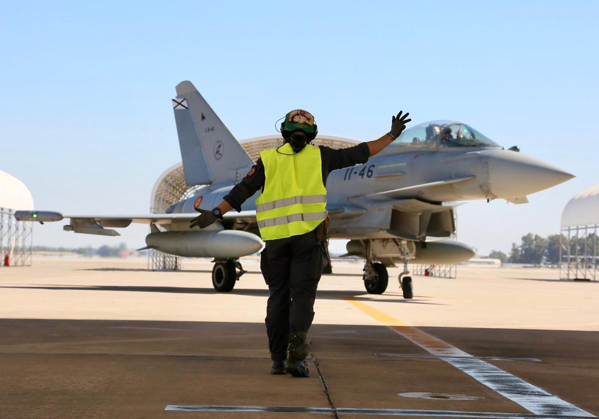 Una asistente en tierra guia a un caza del Ala 11 del Ejército del Aire en la base de Morón.