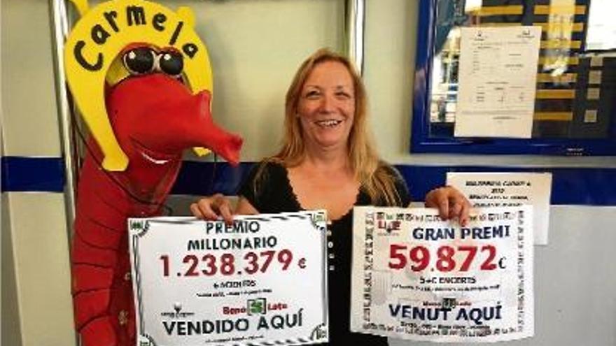 Una treballadora de loteries Carmela, l&#039;administració número 3 de Palamós, mostra els cartells guanyadors.