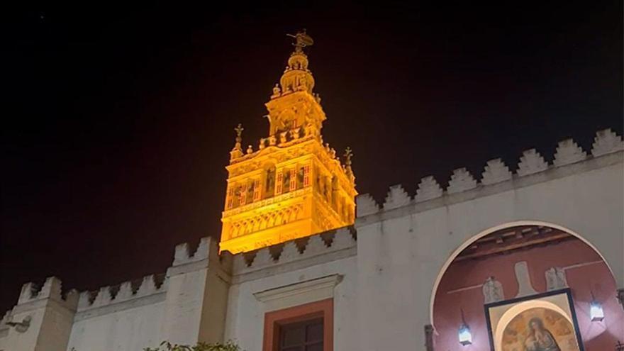 Repican las campanas de la Giralda cuando entra en la calle Alemanes la cruz alzada de la Esperanza de Triana
