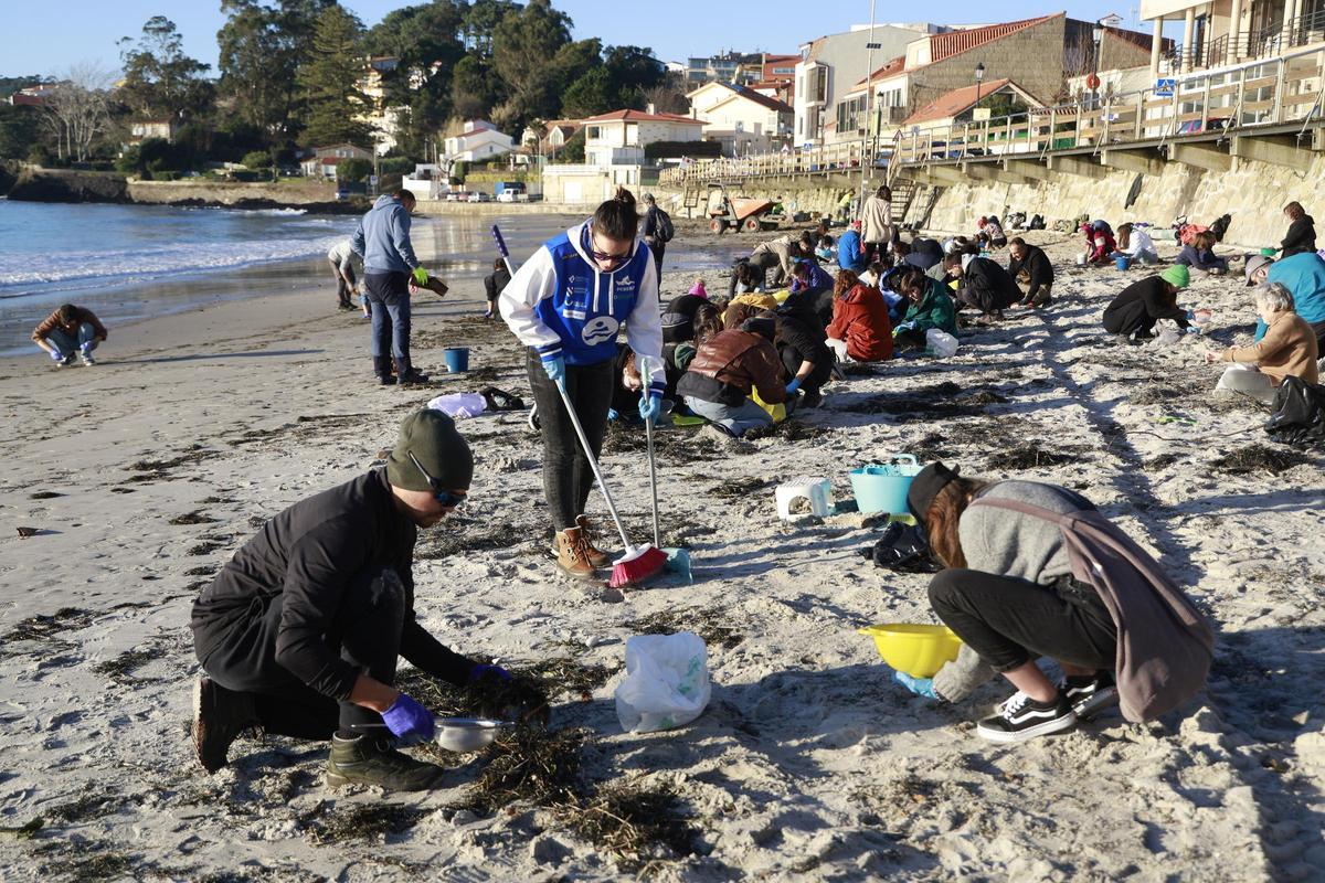 Voluntarios cogiendo pellets en la playa de A Madorra