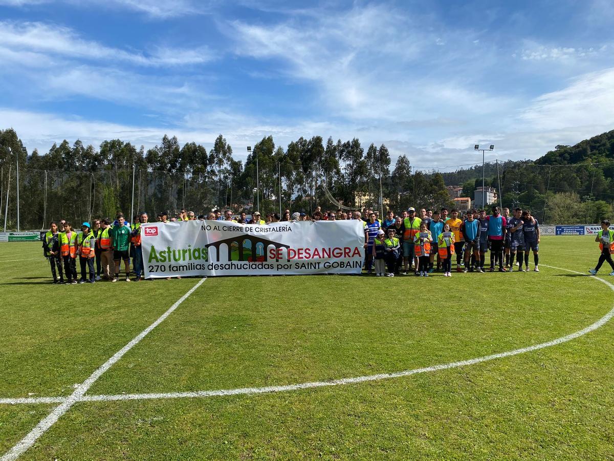 El plantel del Stadium Avilés, ayer, con miembros del comité de Saint-Gobain en el campo del Praviano.