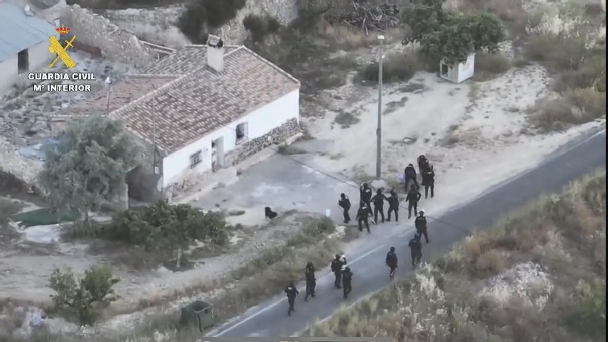 Agentes fuertemente armados entran en la casa aislada en el campo para detener al presunto homicida.