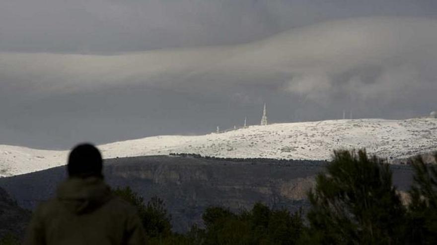 Un hombre observa desde el pantano de Amadorio los efectos de la última nevada en la provincia