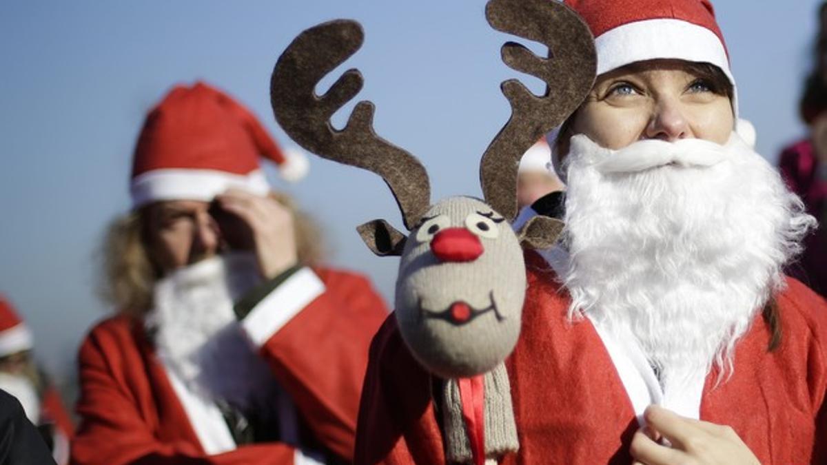 Varias personas vestidas de Papa Noel, en Turín.