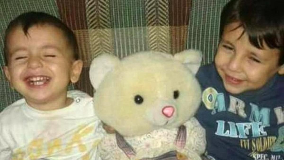 Aylan, de 3 años, y su hermano mayor Galip, de 5, ríen mientras juegan con un osito de peluche.