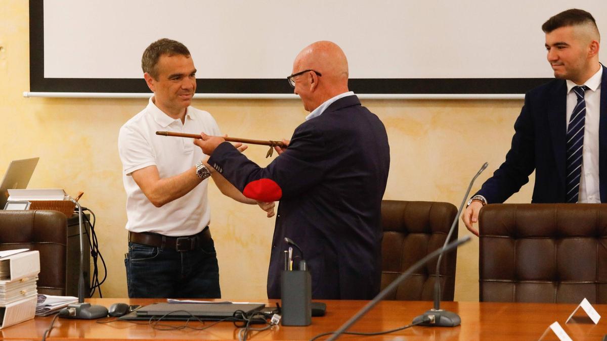 Iván Fernández recibe el bastón de alcalde de manos del edil socialista José Luis Montes con el portavoz del PP, Alejandro Méndez, a la derecha de la imagen.