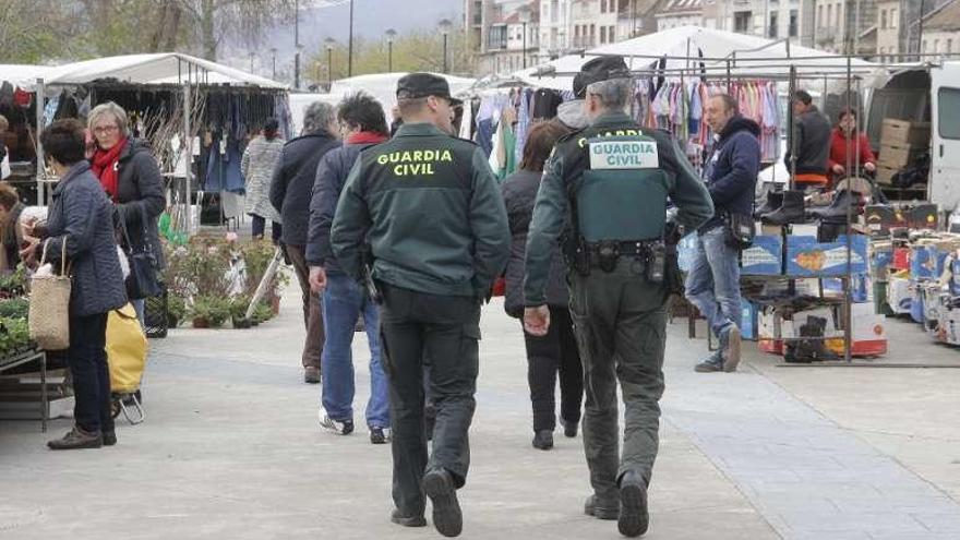 Una pareja de guardias civiles controla el mercadillo de ayer. // S.A.