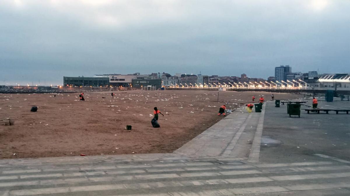 Operarios de Emulsa, limpiando la playa de Poniente tras la hoguera de San Juan de 2023.