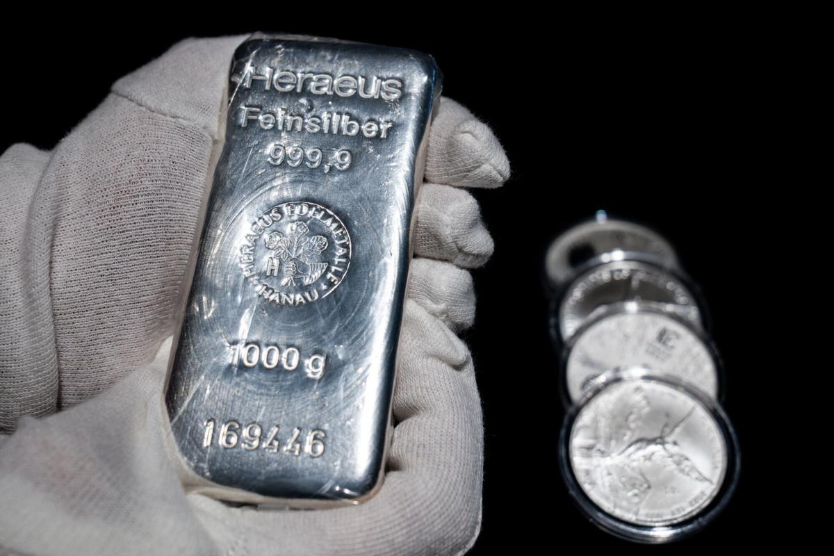 A one kilogram fine silver bar and silver coins at a Goldenmark bullion dealer arranged in Warsaw, Poland, on Wednesday, Jan. 28, 2026. Gold surged to a record above $5,500 an ounce, extending a breakneck rally fueled by a weaker dollar and investor flight from sovereign bonds and currencies to a ninth day. Photographer: Damian Lemanski/Bloomberg