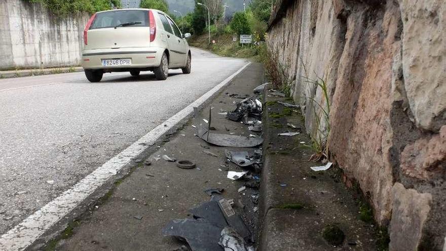 Cristales y restos de la defensa de uno de los vehículos involucrados en el choque, en el entorno del centro de transportes de Mieres.