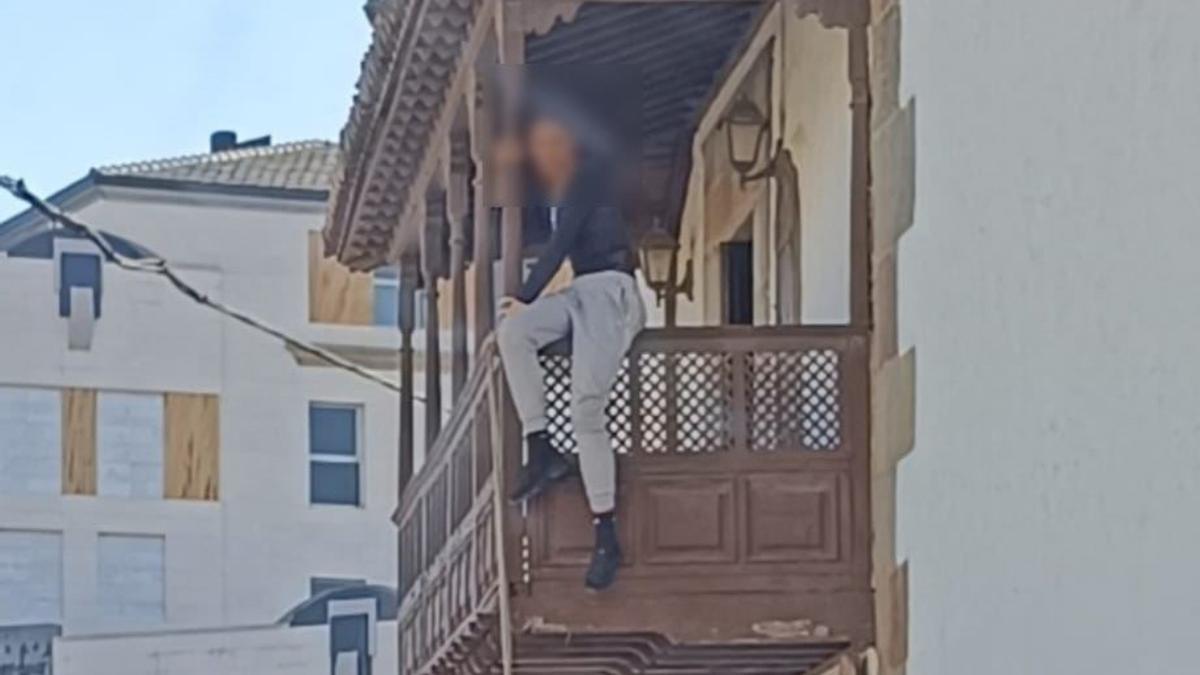 Foto cedida de una las presuntas ladronas, intentando salir por el balcón de la Sacristía.