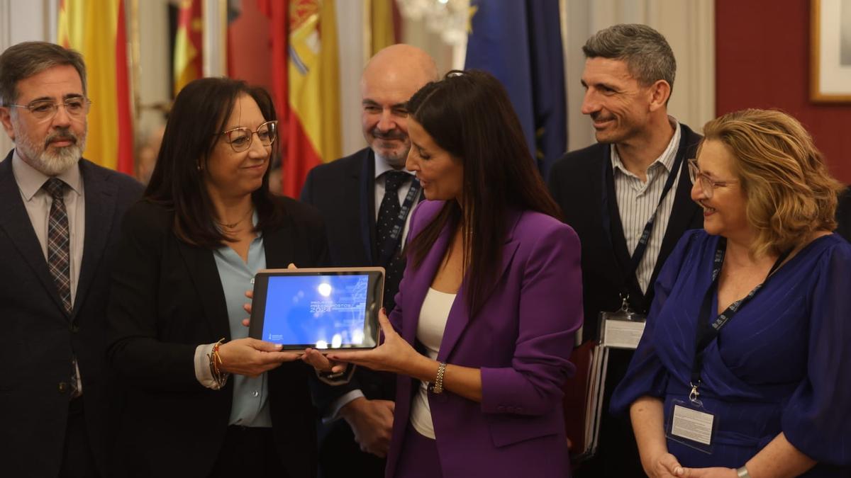 La consellera de Hacienda, Ruth Merino, hace entrega del archivo con los presupuestos de 2024 a la presidenta de las Corts, Llanos Massó