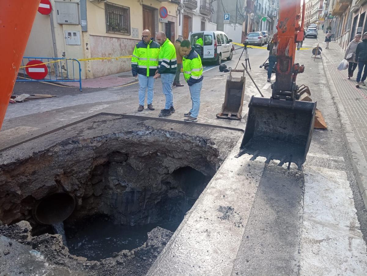 El alcalde de Rute, el concejal de Urbanismo y un operario municipal examinan el socavón abierto tras hundirse la calzada en la calle Juan Carlos I por el temporal.
