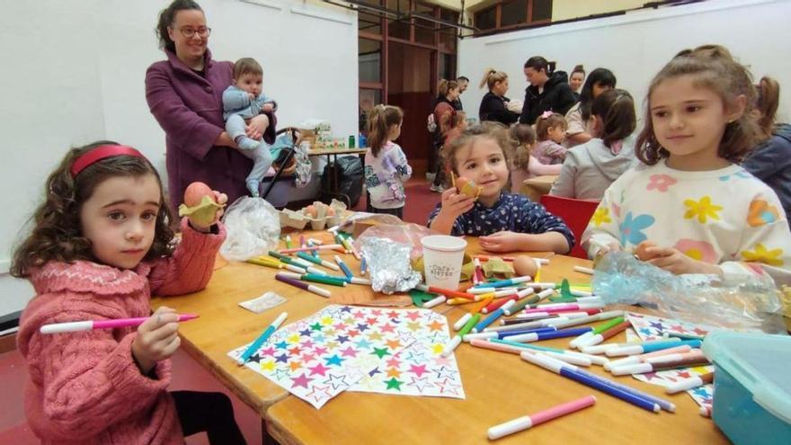 Por la izquierda, Sasha Núñez, Olivia Suárez y Chloe Blanco muestran los huevos  decorados, con Diana Cuenco y la pequeña Matilda detrás. | M. Á. G.