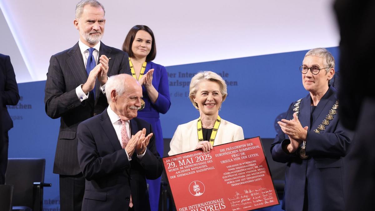 La presidenta de la Comisión Europea, Ursula von der Leyen, con el certificado del Premio Carlomagno, este jueves en Aquisgrán (Alemania), es aplaudida por Felipe VI y autoridades de la ciudad.