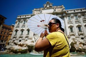 Una turista se refugia del calor en la Fontana di Trevi.