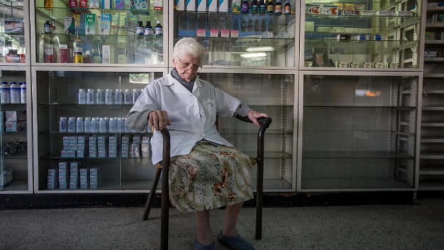 Una anciana espera por unos medicamentos en una farmacia desabastecida de Caracas.