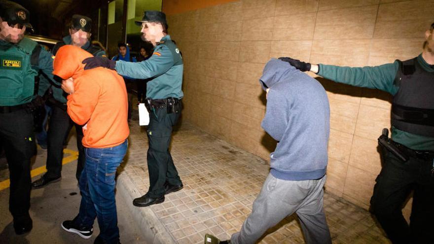 Dos de los detenidos son introducidos en el furgón.