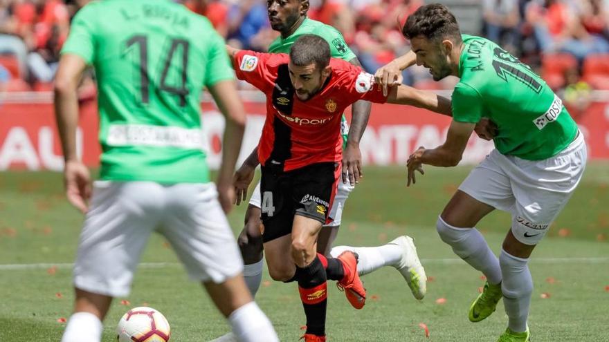 Dani RodrÃ­guez intenta irse del marcaje de dos jugadores del AlmerÃ­a, el domingo.