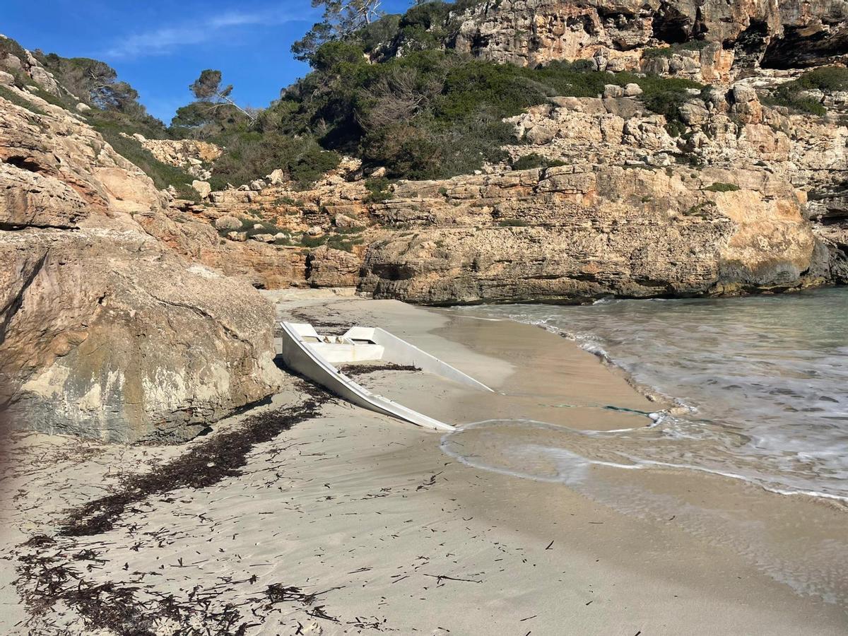 Ein Migrantenboot im Süden Mallorcas, das Wrack wird bereits fast vollständig vom Sand verschluckt.