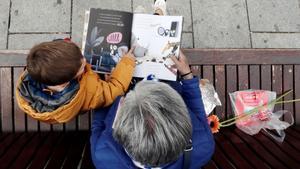 Un niño escucha a su abuela en la lectura de un libro adquirido en la Feria del Libro, en una imagen de archivo.