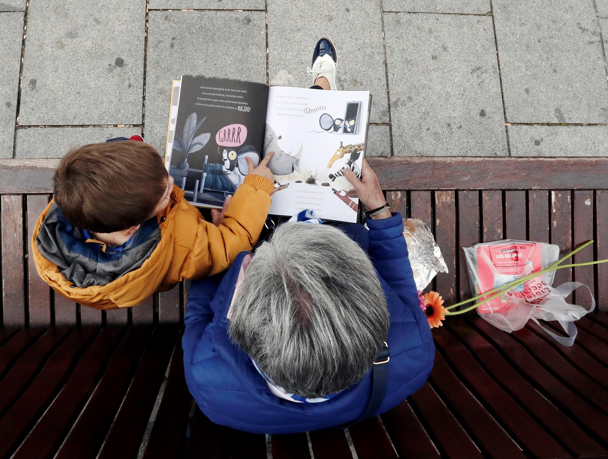 Un niño escucha a su abuela en la lectura de un libro adquirido en la Feria del Libro de Pamplona, en una imagen de archivo.