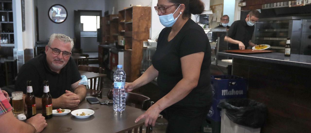 Una camarera en un bar de Picanya atiende a unos clientes.