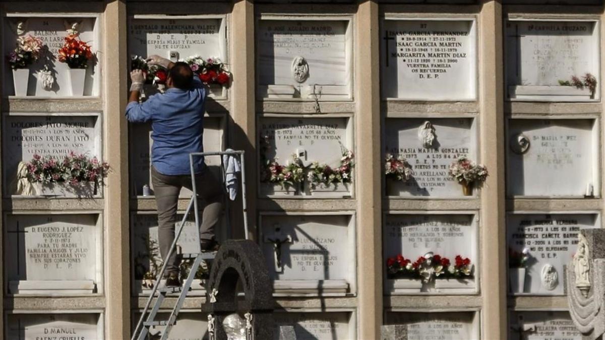 Un hombre sobre una escalera en un cementerio.