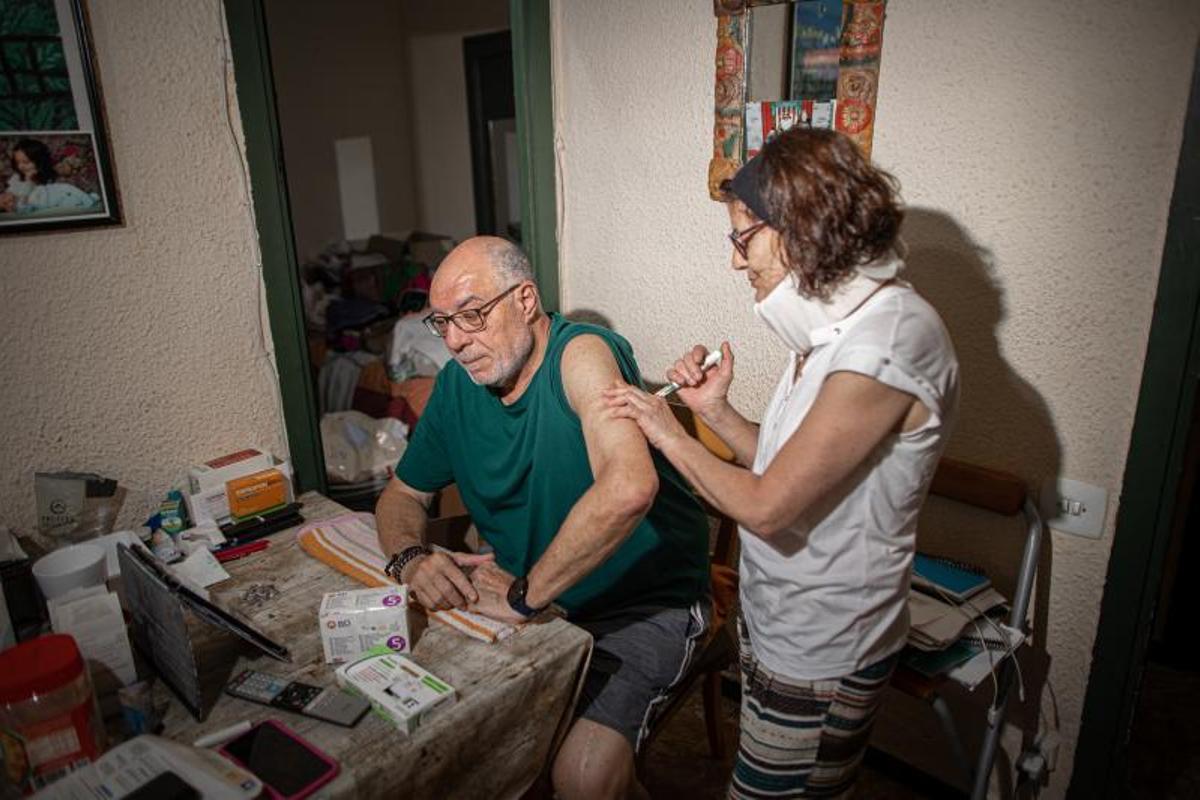 Manoli Vázquez le pone insulina a su marido, Ginés Subirà, en su piso del barrio de Sant Crist en Badalona.