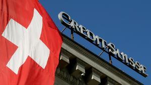 FILE PHOTO: Switzerland’s national flag flies next to the logo of Swiss bank Credit Suisse at a branch office in Luzern, Switzerland October 19, 2017.   REUTERS/Arnd Wiegmann/File Photo                    GLOBAL BUSINESS WEEK AHEAD