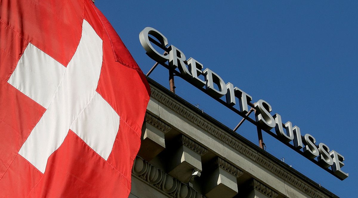 FILE PHOTO: Switzerland's national flag flies next to the logo of Swiss bank Credit Suisse in Luzern