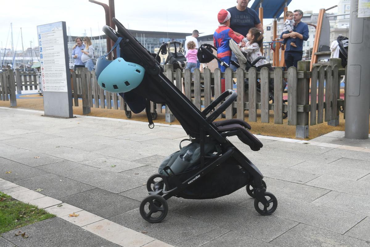Silla de paseo delante de un parque infantil de A Coruña.