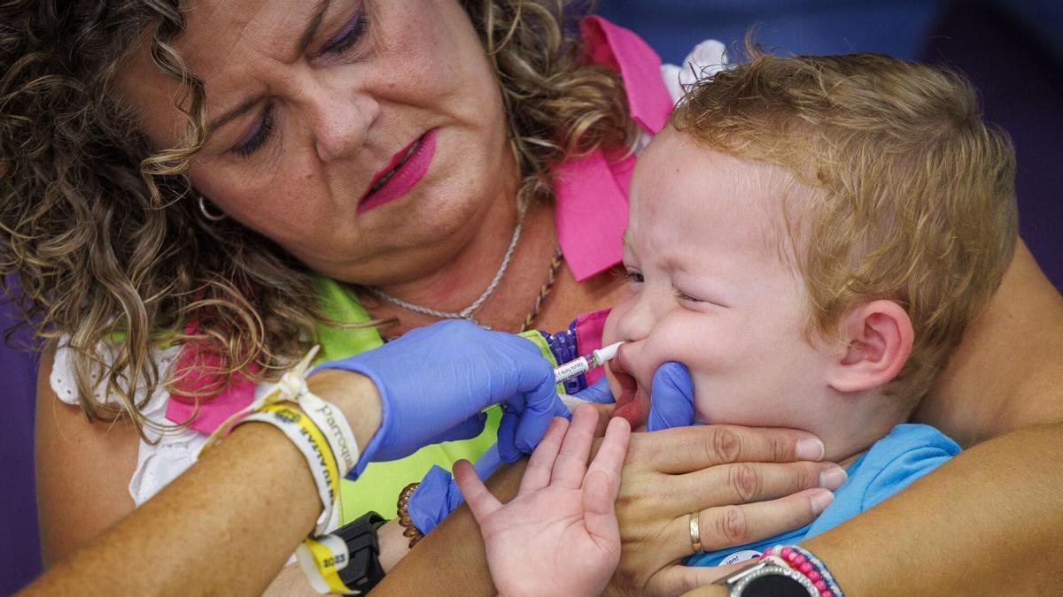 Una sanitaria vacuna a un niño en un centro educativo de Sevilla, en el arranque de la campaña de vacunación contra la gripe.