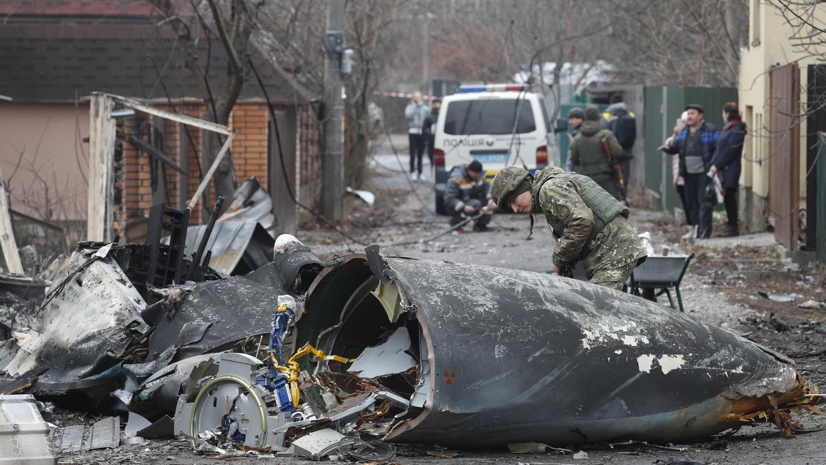 Un soldado observa los restos de un avión militar derribado en Kiev, Ucrania.