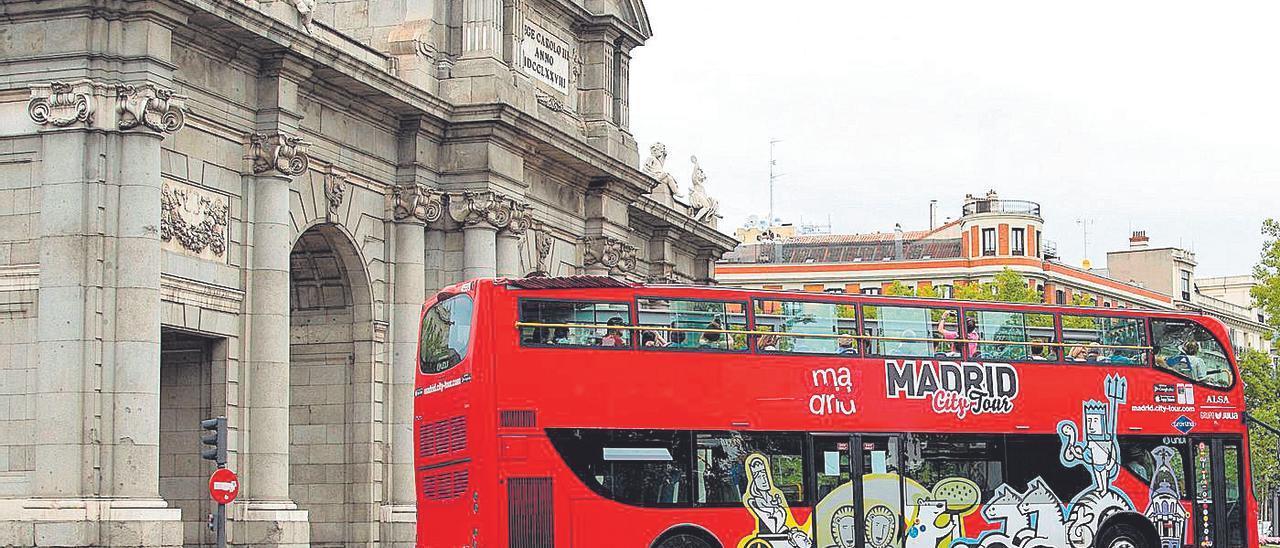 Un autobús turístico de la ciudad de Madrid a su paso por la céntrica Puerta de Alcalá.