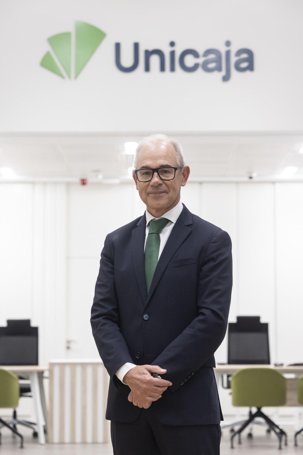 El consejero delegado de Unicaja Banco, Isidro Rubiales, bajo el nuevo logo.