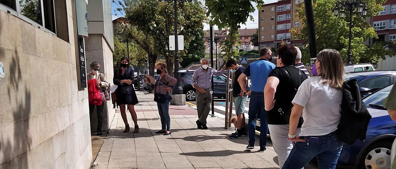 Vecinos, ayer, esperando en el centro de salud de Otero para ser atendidos en el mostrador. | C. O