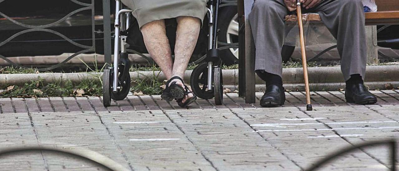 Una pareja de ancianos descansan en Alicante en un banco del paseo del General Marvá. PILAR CORTÉS