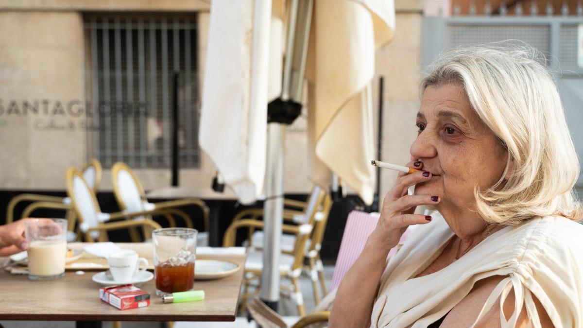 Una mujer fumando en una terraza este martes en Cáceres