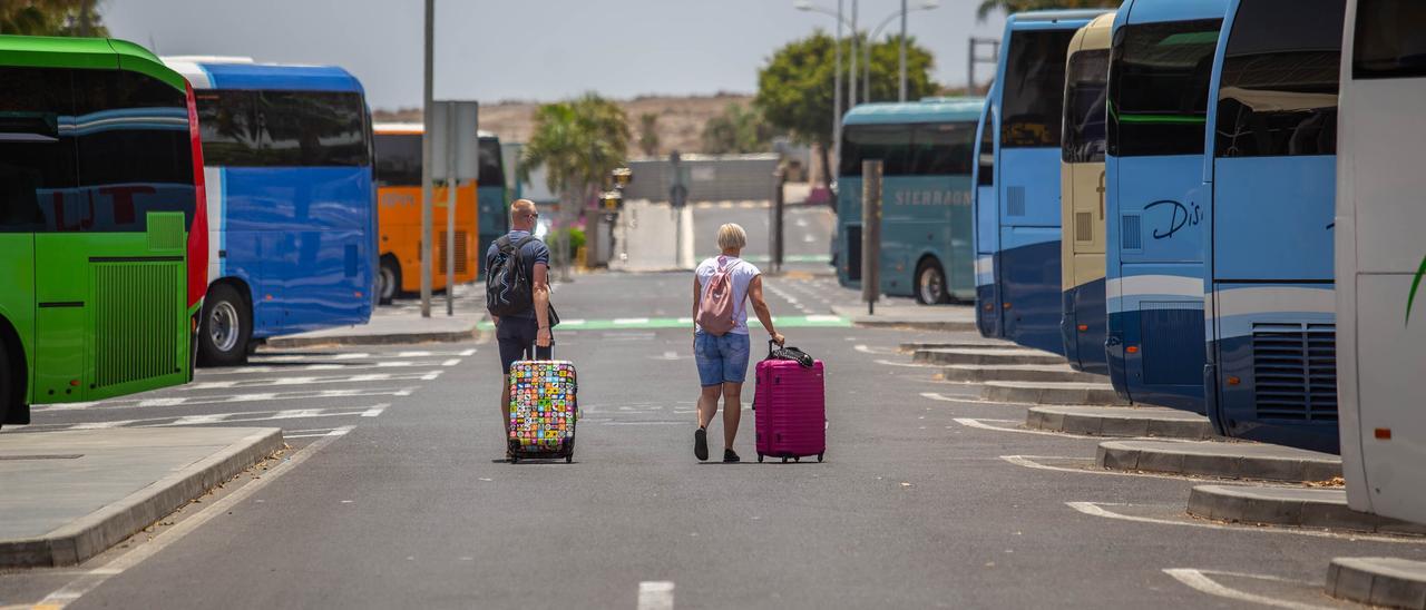 Una pareja de turistas extranjeros arrastra sus maletas a la salida del aeropuerto Tenerife Sur.