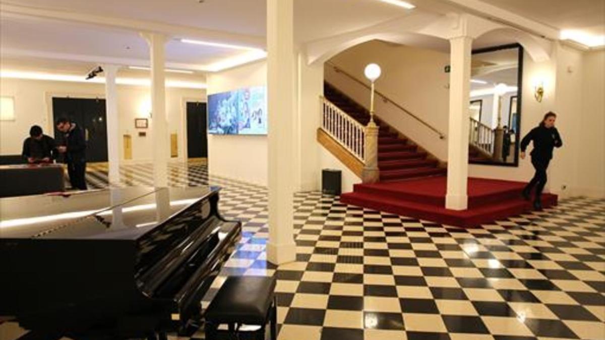 Vestíbulo del Teatre Romea, en el que hay un piano y una imponente escalera.