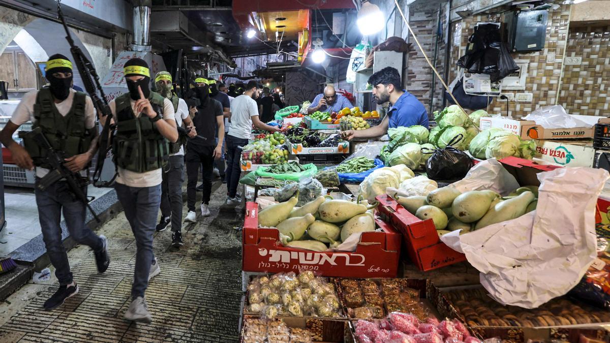 Militantes enmascarados de Fatah marchan a través de un antiguo mercado en el centro de la ciudad de Nablus