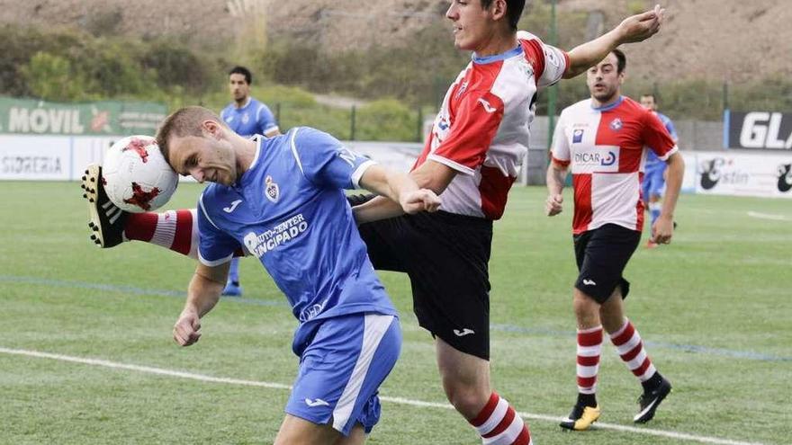 El jugador del Covadonga Mikel trata de llevarse el balón con la cabeza ante la oposición de Javi Alonso.