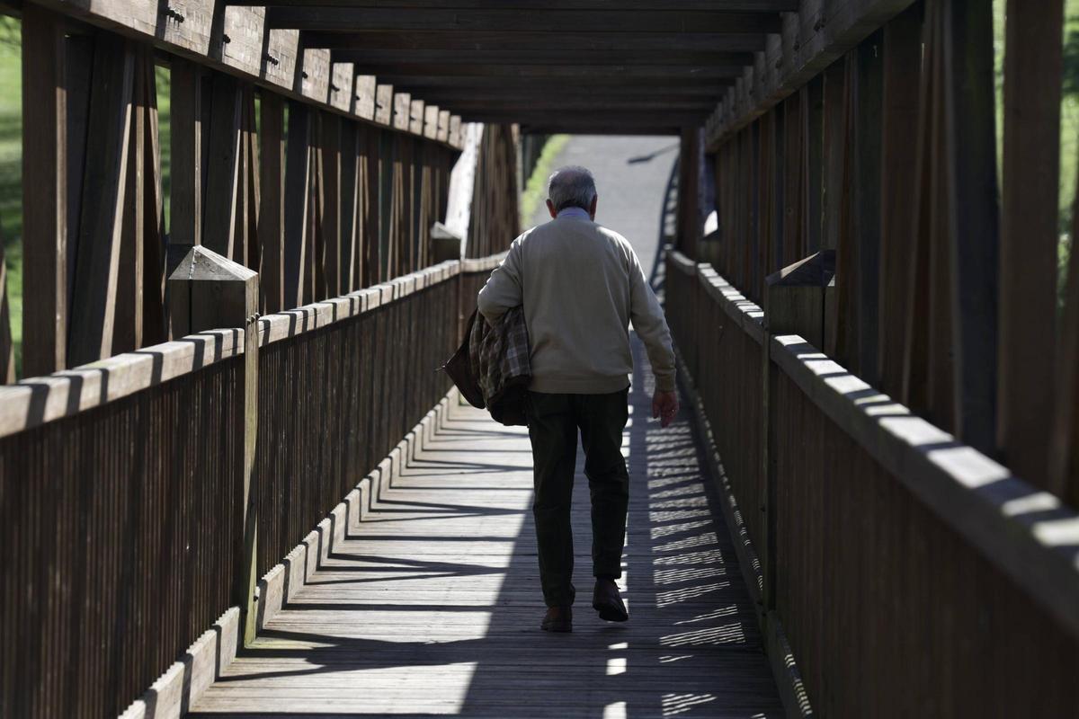 Un jubilado camina por el puente de madera del Parque de Invierno