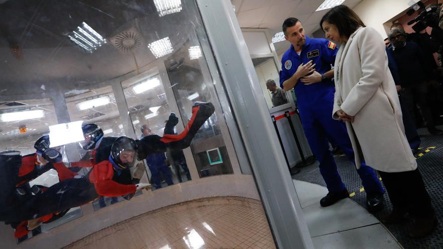 La ministra de Defensa, Margarita Robles, observa a varias personas en el simulador de caída libre, también conocido como túnel de viento, en la Base Áerea de Alcantarilla (Murcia).