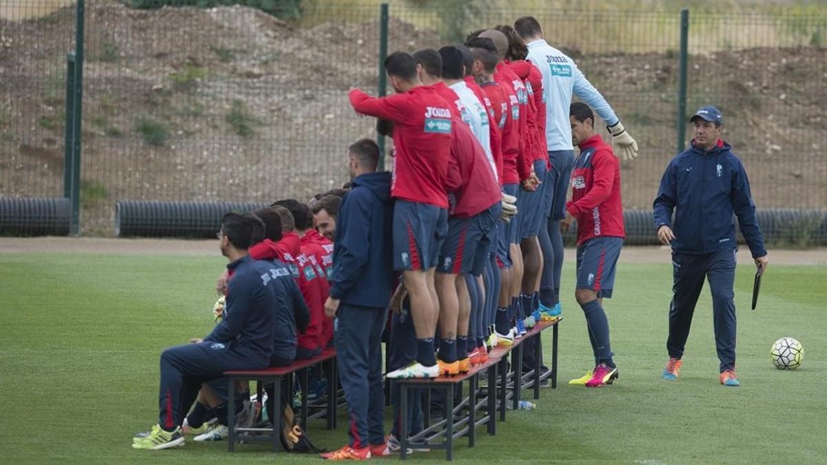 El entrenador del Granada, José González, observa a sus jugadores mientras se hacen una foto de grupo antes del entrenamiento de este jueves