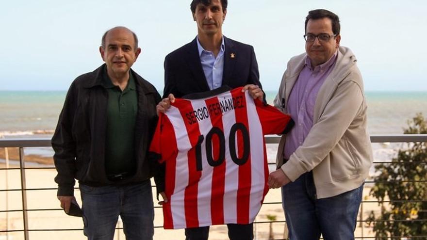 Luis Hernández (i) y Josep Miquel García (d), integrantes de la comisión del Centeranio del Hércules le entregan la camiseta a Sergio Fernández.