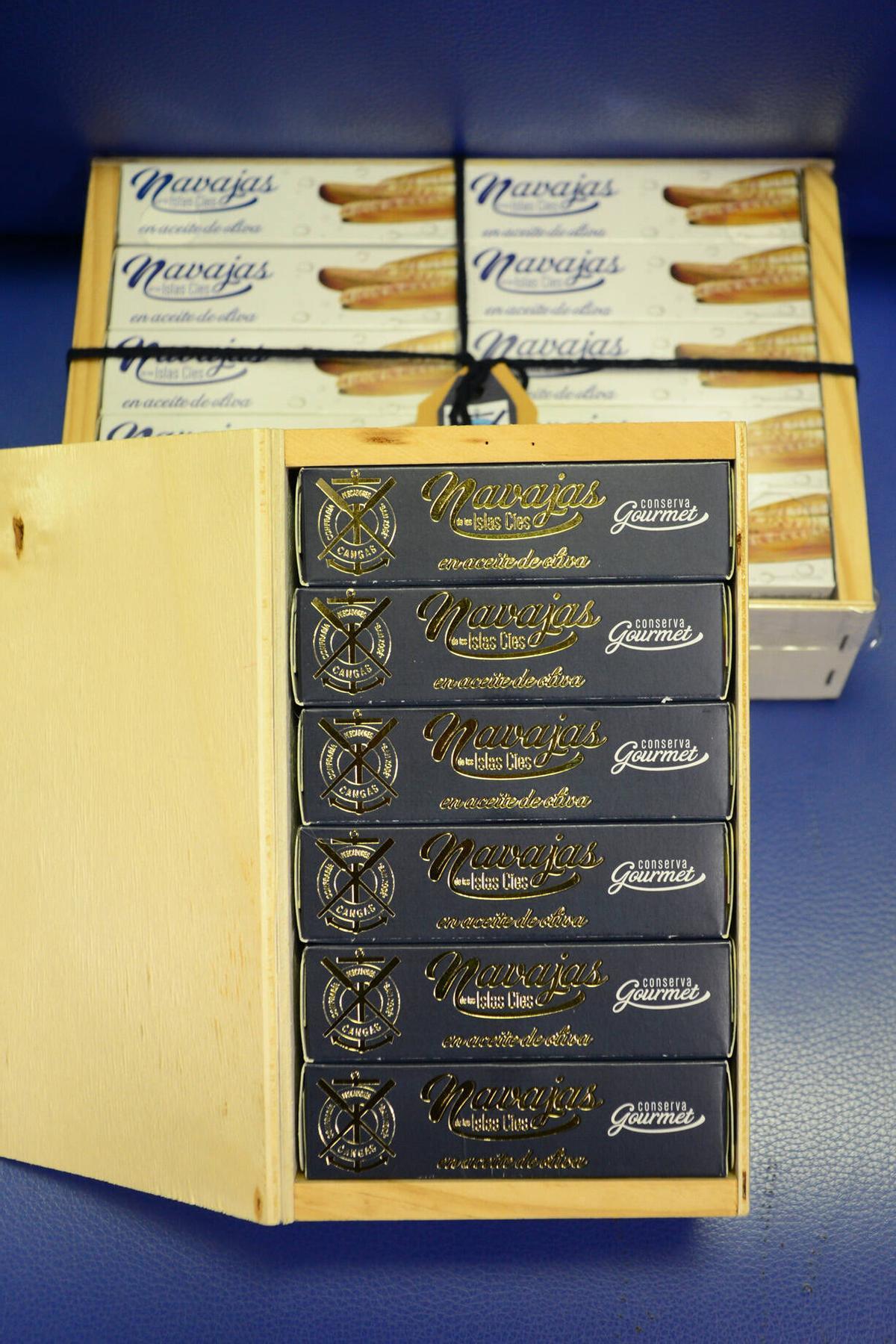 Estuches de latas de navajas de Cíes con su nuevo diseño en primer plano y el antiguo al fondo.